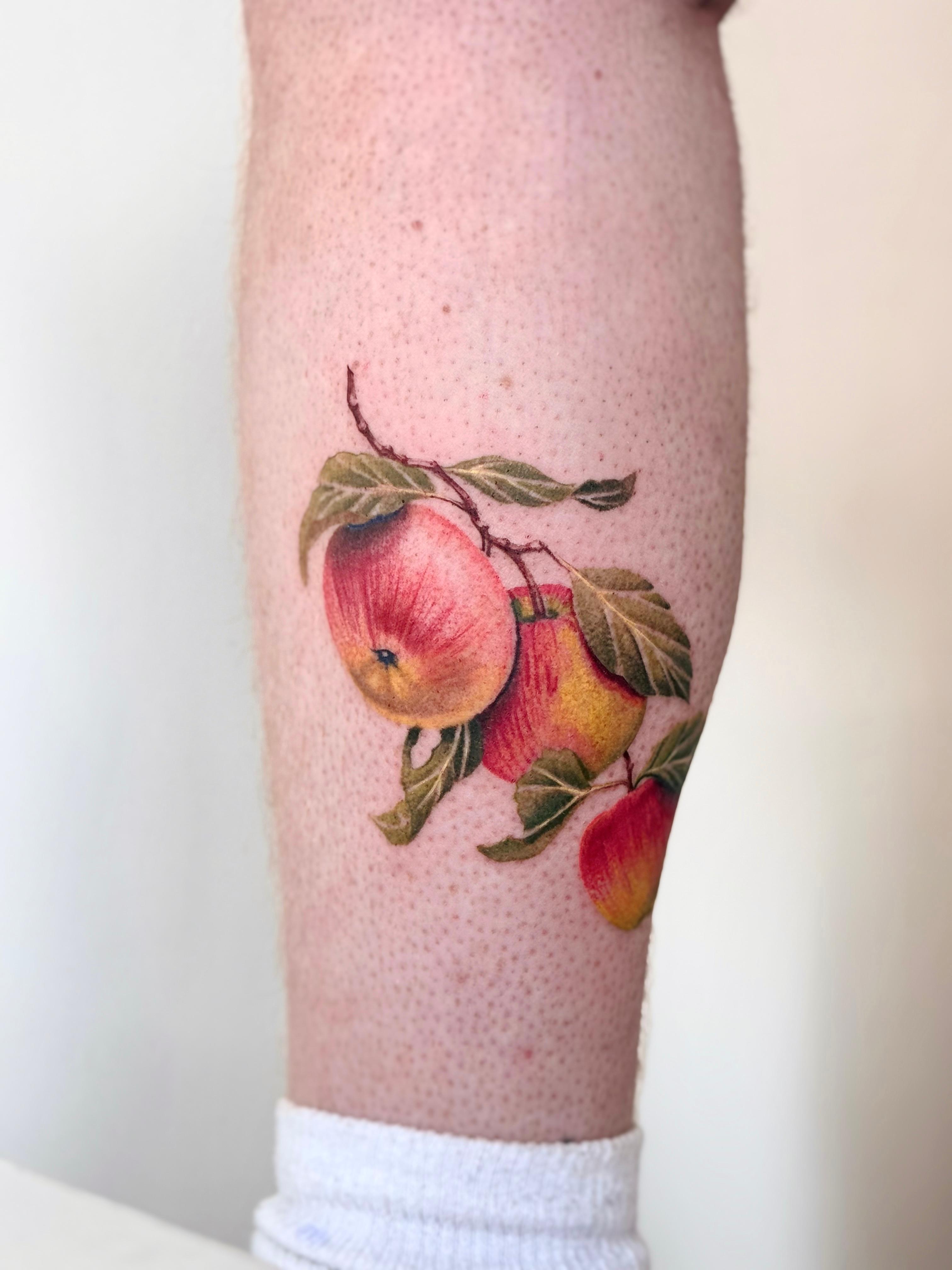 Color apple branch tattoo on the lower leg